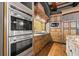 Modern kitchen with double ovens, ample storage, and wood flooring at 7725 Still Lakes Dr, Odessa, FL 33556