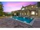 Stunning pool and patio at sunset, with beautiful home in the background at 7725 Still Lakes Dr, Odessa, FL 33556