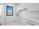 Bright laundry room with white cabinets, marble countertops and a window at 2519 N Riverside Dr, Tampa, FL 33602