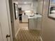 View of kitchen from hallway, showing tile floor and white cabinets at 36750 Us Highway 19 N # 15-310, Palm Harbor, FL 34684