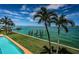 Backyard oasis featuring manicured lawn, palm trees, pool, and private boat dock at 806 Columbus Dr, Tierra Verde, FL 33715