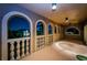 The arched balcony at nighttime, beautifully lit and decorated with balusters, presents a captivating scene of the nearby neighborhood at 806 Columbus Dr, Tierra Verde, FL 33715