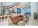 Open dining room with a large wood table, seating, and staircase at 806 Columbus Dr, Tierra Verde, FL 33715