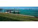 A wooden dock extends over a lush green lawn and into tranquil turquoise waters at 806 Columbus Dr, Tierra Verde, FL 33715