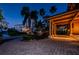 Covered entryway with lighting and seating at night at 806 Columbus Dr, Tierra Verde, FL 33715