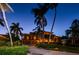 Stunning home exterior illuminated at night with palm trees at 806 Columbus Dr, Tierra Verde, FL 33715