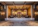 Elegant home entrance with double doors and stone steps at night at 806 Columbus Dr, Tierra Verde, FL 33715