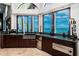Cozy kitchen with granite counters, dark cabinetry, and a view of the water through expansive windows at 806 Columbus Dr, Tierra Verde, FL 33715