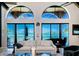 Bright living room with ocean view through arched windows and slider doors at 806 Columbus Dr, Tierra Verde, FL 33715