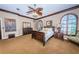 Well-lit main bedroom showcasing rich wood furniture, arched windows, and a comfortable sitting area at 806 Columbus Dr, Tierra Verde, FL 33715