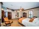 Comfortable main bedroom with a ceiling fan, rocking chair, and a glimpse of the ensuite bathroom at 806 Columbus Dr, Tierra Verde, FL 33715