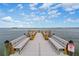 Wooden dock with benches overlooking the water at 300 Woodette Dr # 203, Dunedin, FL 34698