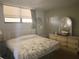 Bright bedroom with a large bed, dresser, and window coverings at 300 Woodette Dr # 203, Dunedin, FL 34698