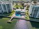 Community pool with lounge chairs and waterfront access at 300 Woodette Dr # 203, Dunedin, FL 34698