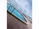 Community pool with brick patio and waterfront view at 300 Woodette Dr # 203, Dunedin, FL 34698