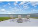 Concrete fire pit with chairs overlooking the water at 300 Woodette Dr # 203, Dunedin, FL 34698