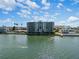 Aerial of waterfront condo building with swimming people at 300 Woodette Dr # 203, Dunedin, FL 34698