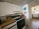 Bright kitchen with white cabinets and electric stove at 300 Woodette Dr # 203, Dunedin, FL 34698
