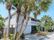 Two-story house with gray siding, palm trees, and a garage at 131 E Bay Dr, Treasure Island, FL 33706
