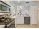 Kitchen features white cabinets, stainless steel appliances, and a breakfast bar at 6428 Gloria Dr # 15, New Port Richey, FL 34653