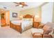 Main bedroom with king bed, ceiling fan, and wicker chair at 11 San Marco St # 903, Clearwater, FL 33767