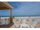 Balcony with white chairs and table, offering stunning ocean views at 11 San Marco St # 903, Clearwater, FL 33767