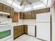 Bright kitchen with white appliances and wood cabinets at 11485 Oakhurst Rd # 107, Largo, FL 33774