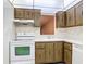 View of kitchen with wood cabinets and white appliances at 11485 Oakhurst Rd # 107, Largo, FL 33774