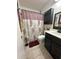 Well-appointed bathroom with tile flooring, a dark vanity, and a stylish shower curtain at 5347 81St N Ln # 22, St Petersburg, FL 33709
