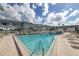 Community pool and sundeck area with lounge chairs, palm trees, and blue skies offer a resort-like experience at 5347 81St N Ln # 22, St Petersburg, FL 33709