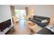 Living room features a comfy leather sofa and access to a relaxing balcony at 948 Virginia St # 205, Dunedin, FL 34698