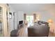 Bright living room with leather sofa, balcony access, and wood-look floors at 948 Virginia St # 205, Dunedin, FL 34698