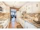 Bright kitchen with white cabinets, granite countertops, and appliances at 5347 81St N Ln # 22, St Petersburg, FL 33709