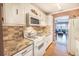 Bright kitchen with white cabinets, granite countertops, and appliances at 5347 81St N Ln # 22, St Petersburg, FL 33709