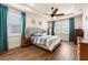 Inviting main bedroom features wood-look tile flooring, teal accents, and plantation shutters on the windows at 1236 Windy Bay Shl, Tarpon Springs, FL 34689