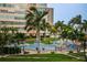 Community pool with lounge chairs and lush tropical landscaping at 5130 Brittany S Dr # 202, St Petersburg, FL 33715