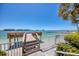 Wooden pier with seating and access to the water at 675 S Gulfview Blvd # 903, Clearwater Beach, FL 33767