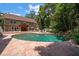 Kidney-shaped pool surrounded by a large stone patio at 327 Lotus Path, Clearwater, FL 33756