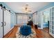 Relaxing sitting room with a blue velvet ottoman and hardwood floors at 327 Lotus Path, Clearwater, FL 33756