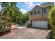 Attached garage with a charming pool and lush landscaping in the background at 327 Lotus Path, Clearwater, FL 33756