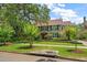 Two-story house with a green facade, brown roof, and manicured lawn at 327 Lotus Path, Clearwater, FL 33756