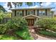 House entrance with a brick walkway and lush landscaping at 327 Lotus Path, Clearwater, FL 33756