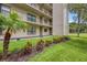 Exterior view of condo building with landscaping and grassy area at 900 Cove Cay Dr # 1H, Clearwater, FL 33760