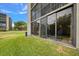 Ground level view of condo with sliding glass doors to sunroom and grassy area at 900 Cove Cay Dr # 1H, Clearwater, FL 33760