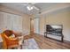 Living room with wood floors, a chair, and a large TV at 900 Cove Cay Dr # 1H, Clearwater, FL 33760