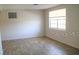 Simple bedroom with light walls, wood-look flooring, and a large window at 4102 Darlington Rd, Holiday, FL 34691