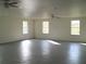 Large bonus room with grey floor, multiple windows and ceiling fans at 4102 Darlington Rd, Holiday, FL 34691