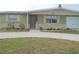 Ranch style home with green exterior, landscaping, and a paved driveway at 4102 Darlington Rd, Holiday, FL 34691