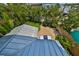 Aerial perspective showcasing a manicured backyard with patio furniture, surrounded by lush tropical foliage at 13004 Boca Ciega Ave, Madeira Beach, FL 33708