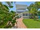 Inviting backyard with a brick pathway, lush greenery, and a glimpse of the home's upper level at 13004 Boca Ciega Ave, Madeira Beach, FL 33708